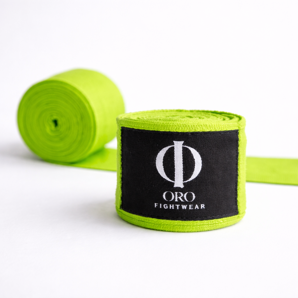 Vendas Verdes ORO enrolladas sobre fondo blanco, con la etiqueta ORO Fightwear al frente