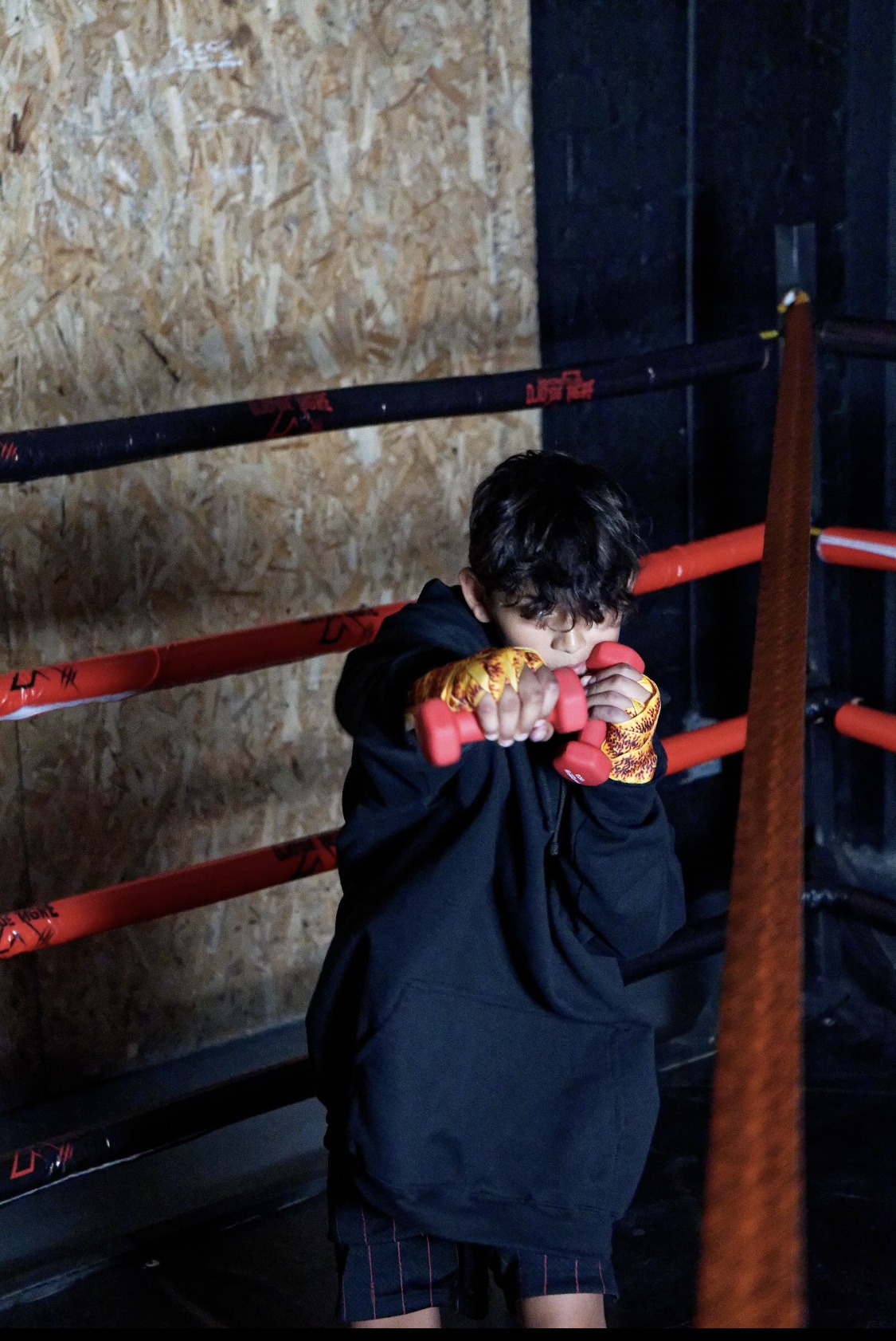 Joven entrenando con pesas dentro del ring