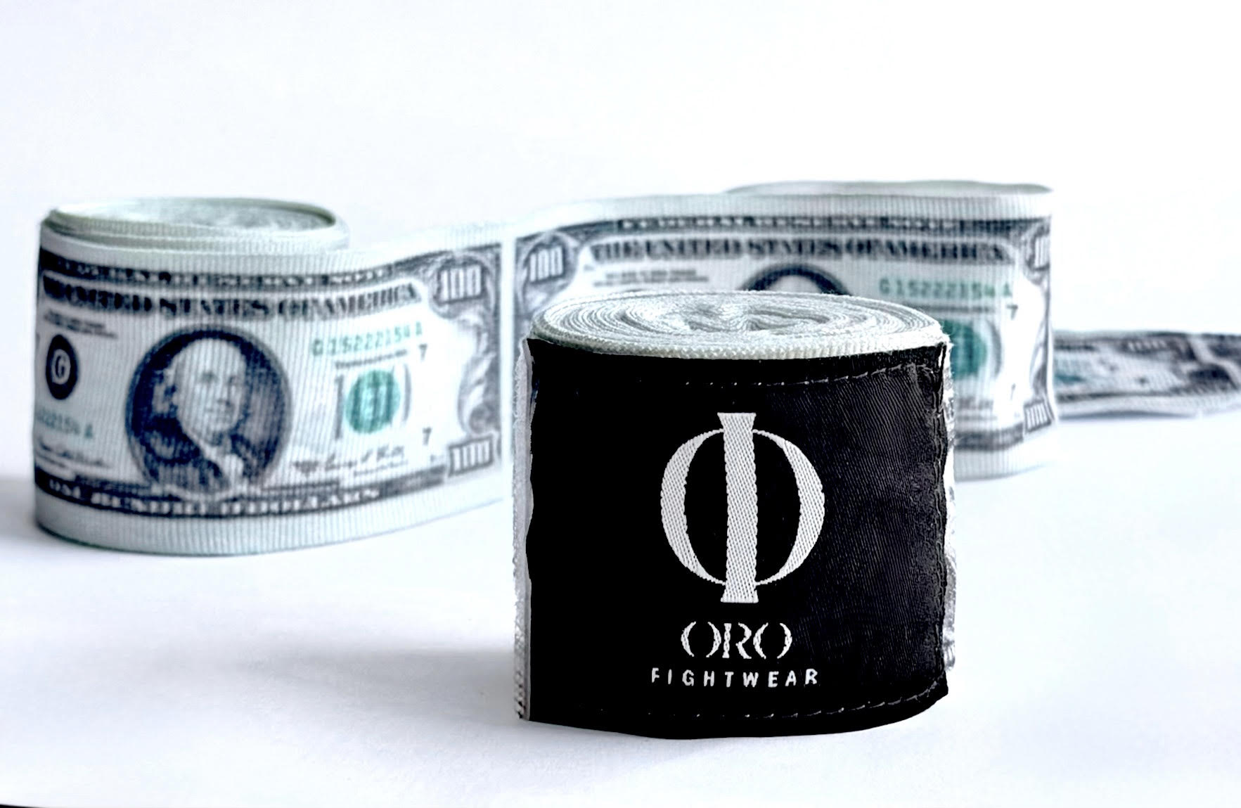 Vendas Dollar enrolladas sobre fondo blanco, con el parche negro ORO Fightwear al frente