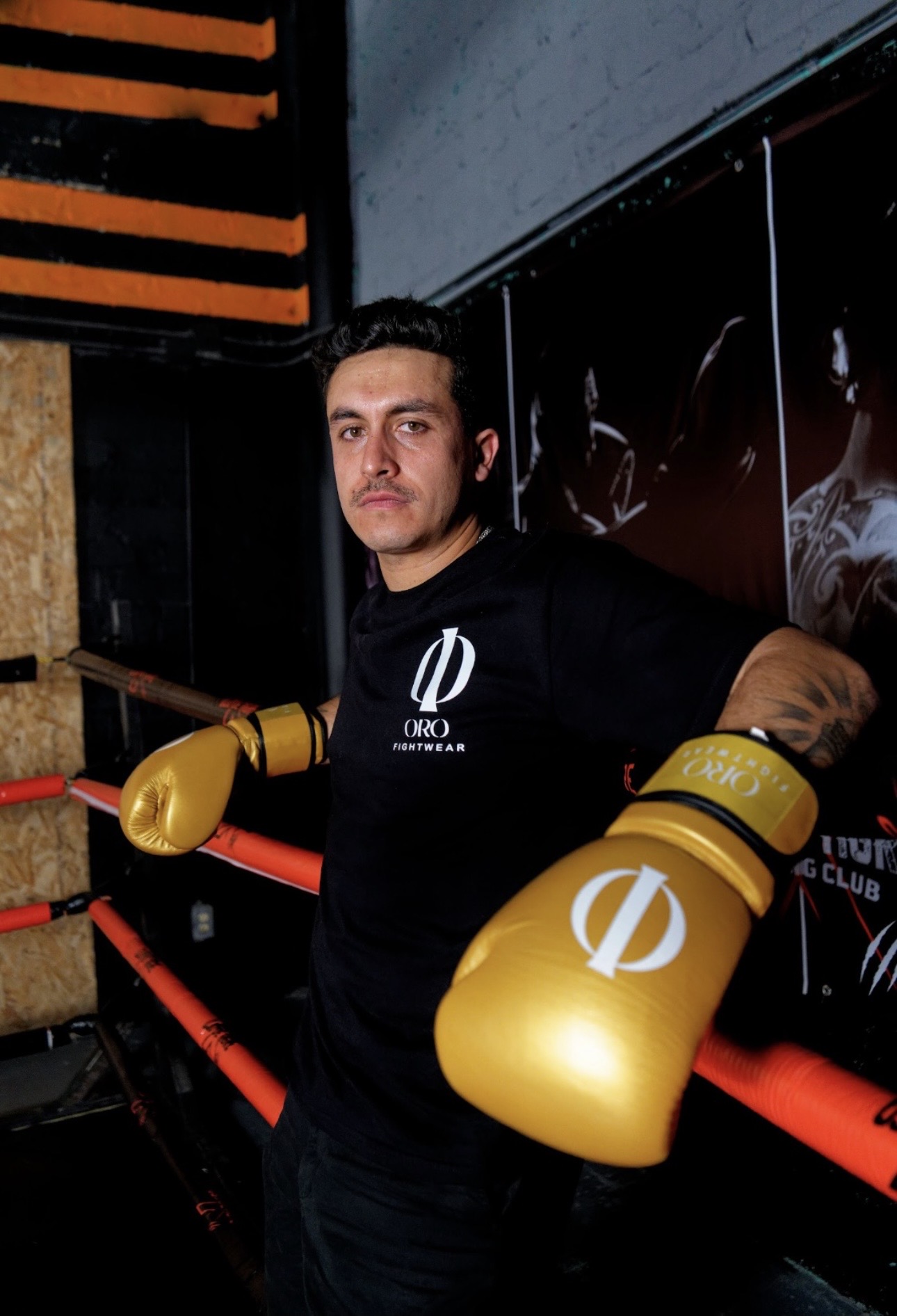 Atleta con guantes dorados ORO recargado en las cuerdas del ring